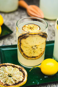 Burnt lemon lemonade in glass garnished with charred lemon slices