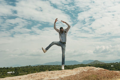 Full length of man standing on mountain against sky
