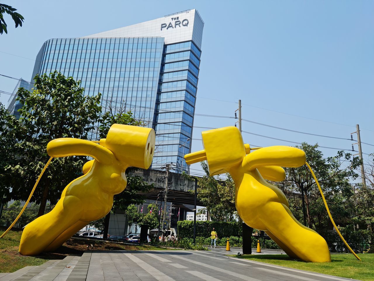 LOW ANGLE VIEW OF YELLOW SCULPTURE AGAINST BUILDINGS