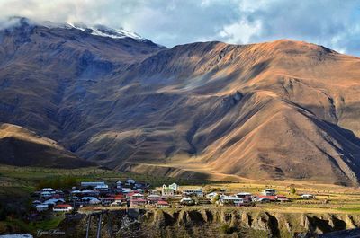 Panoramic view of people on snowcapped mountain against sky