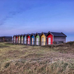 Houses on field against sky