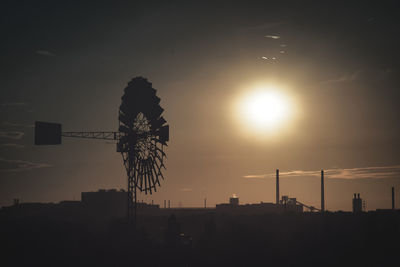 Silhouette ferris wheel against sky during sunset