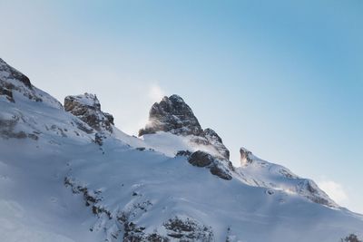 Low angle view of snow covered mountain against clear sky