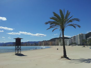 View of calm beach with buildings in the background