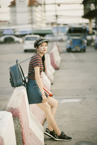 Portrait of young woman sitting on concrete block