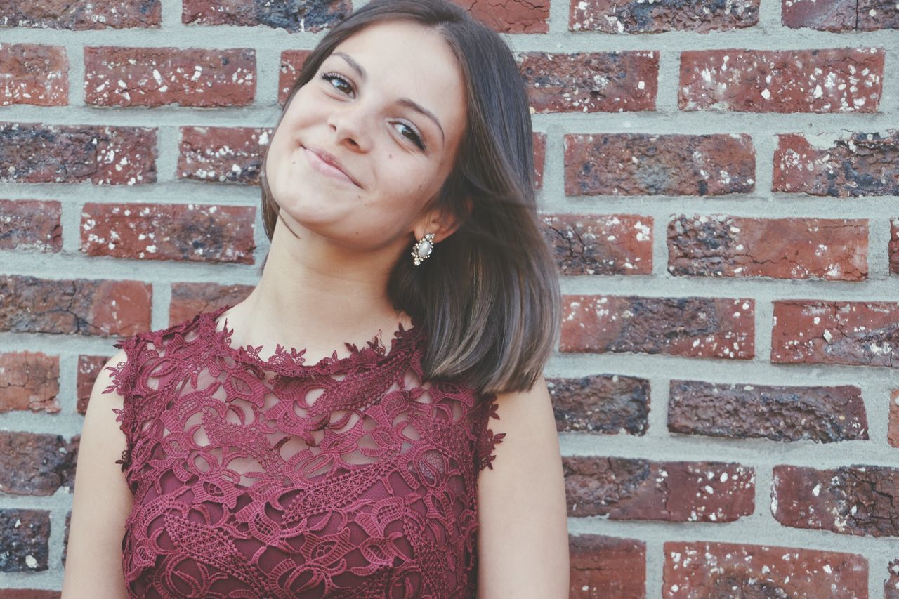 brick wall, one person, real people, young adult, beautiful woman, lifestyles, outdoors, standing, day, portrait, architecture, building exterior, young women, close-up, adult, people