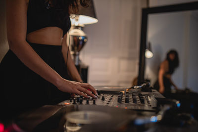 Fashionable young woman playing music at home