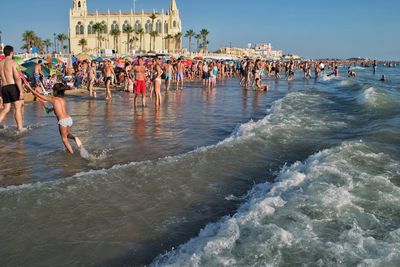 People at beach against sky