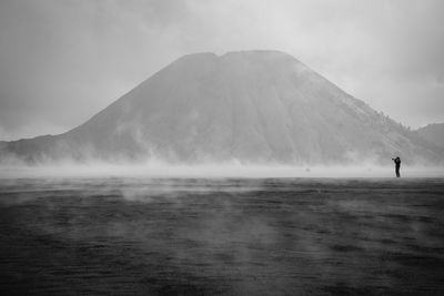 Silhouette man standing at calm sea