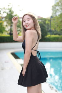 Low angle view of young woman standing against sky