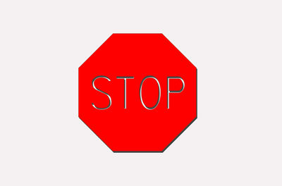 Close-up of red stop sign against white background