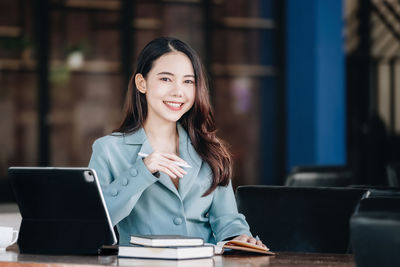 Young woman using laptop at cafe