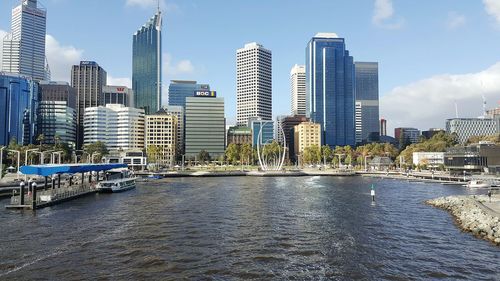 Sea by cityscape against sky