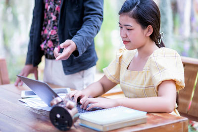 Midsection of woman holding while standing on table