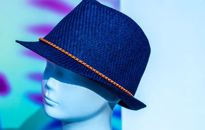 Close-up of mannequin with hat against wall