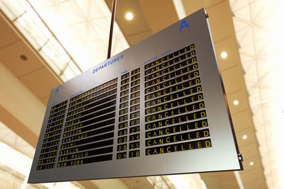 Low angle view of illuminated board at airport