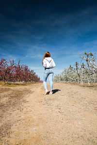 Woman standing on field against sky