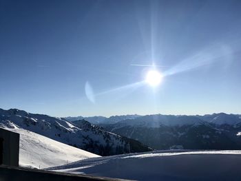 Scenic view of snowcapped mountains against sky on sunny day