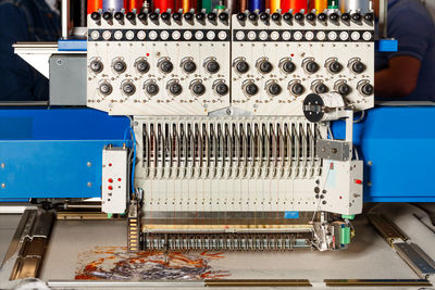 Industrial programmable embroidery machine with multicolored threads at work. closeup. copy space.