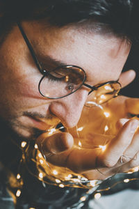 Close-up of man holding string light