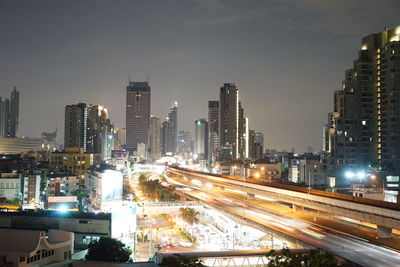 Illuminated buildings in city against sky at night