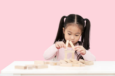 Portrait of girl with toy against gray background