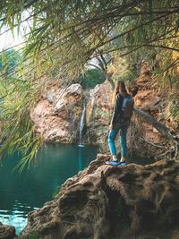 Woman standing and overlooking waterfall