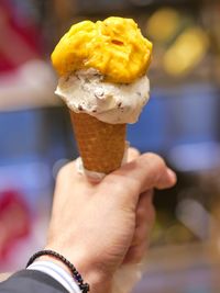 Close-up of hand holding ice cream cone