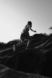 Low angle view of man riding woman against clear sky