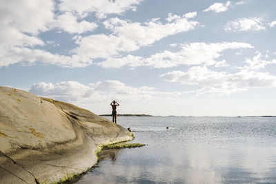 Silhouette of woman at rocky coast