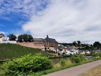 Buildings by road against sky in city