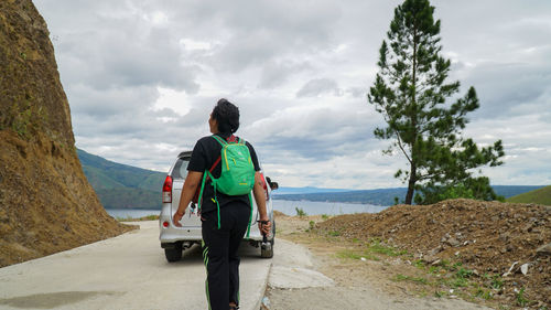 Rear view of man on road against sky