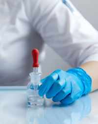 Midsection of doctor holding dental equipment