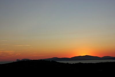 Scenic view of silhouette mountains against romantic sky at sunset