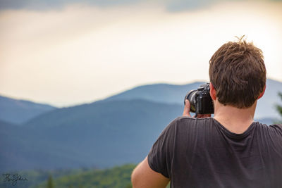 Rear view of man photographing