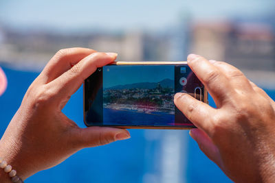 Midsection of person photographing with mobile phone