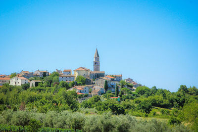 View of cityscape against clear blue sky