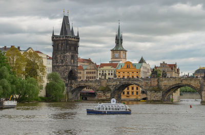 Arch bridge over river against buildings in city