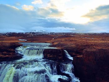 Scenic view of waterfall against sky