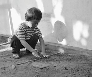 Toddler playing by wall