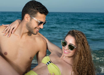 Portrait of young couple kissing in sea