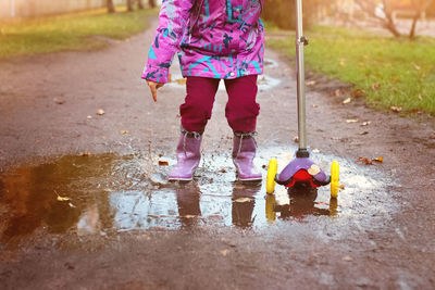 Low section of woman standing in puddle