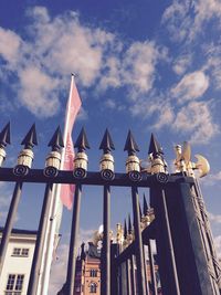 Low angle view of metallic fence against sky