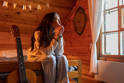 Frustrated confused asian young woman feeling anxious after reading bad news looking away at window