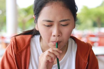 Close-up of woman drinking with straw