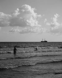Woman in sea against sky