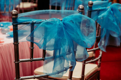 High angle view of blue fabrics tied up on chairs at wedding ceremony