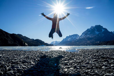 Man surfing in sea against sky on sunny day