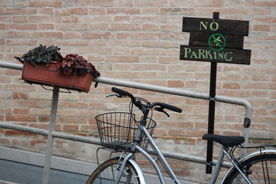 Bicycle sign against brick wall in city