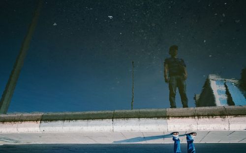 People standing in water against sky